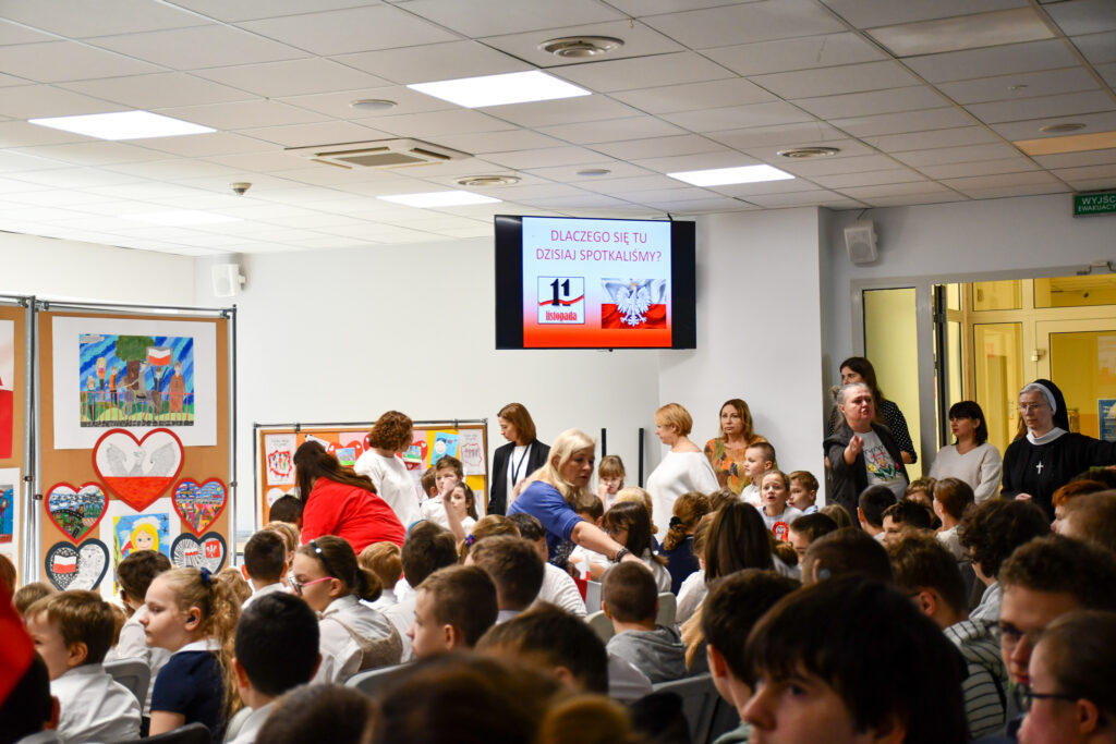 Widok sali pełnej uczniów i nauczycieli podczas uroczystego apelu.