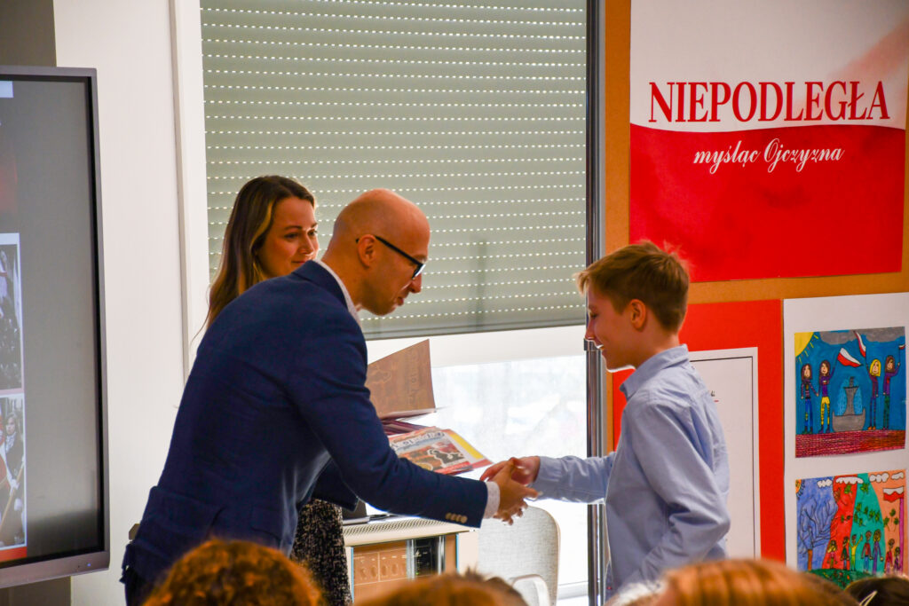 Uczennica odbierająca nagrodę podczas uroczystości.