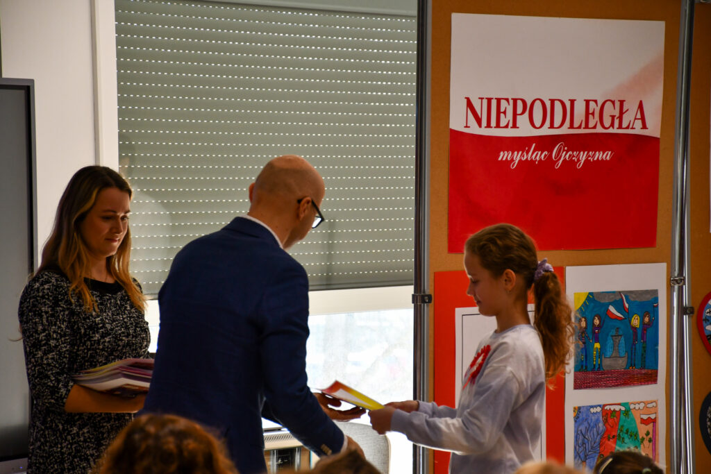 Uczennica odbierająca nagrodę podczas uroczystości.