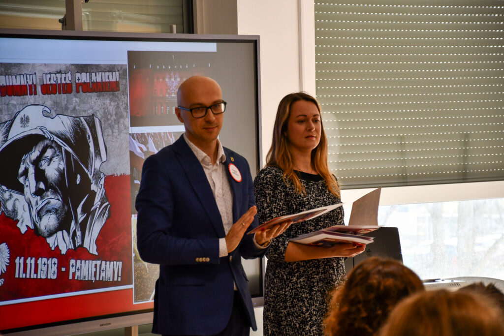 Dyrektor bije brawo dla uczestników konkursu. Obok stoi prowadząca.